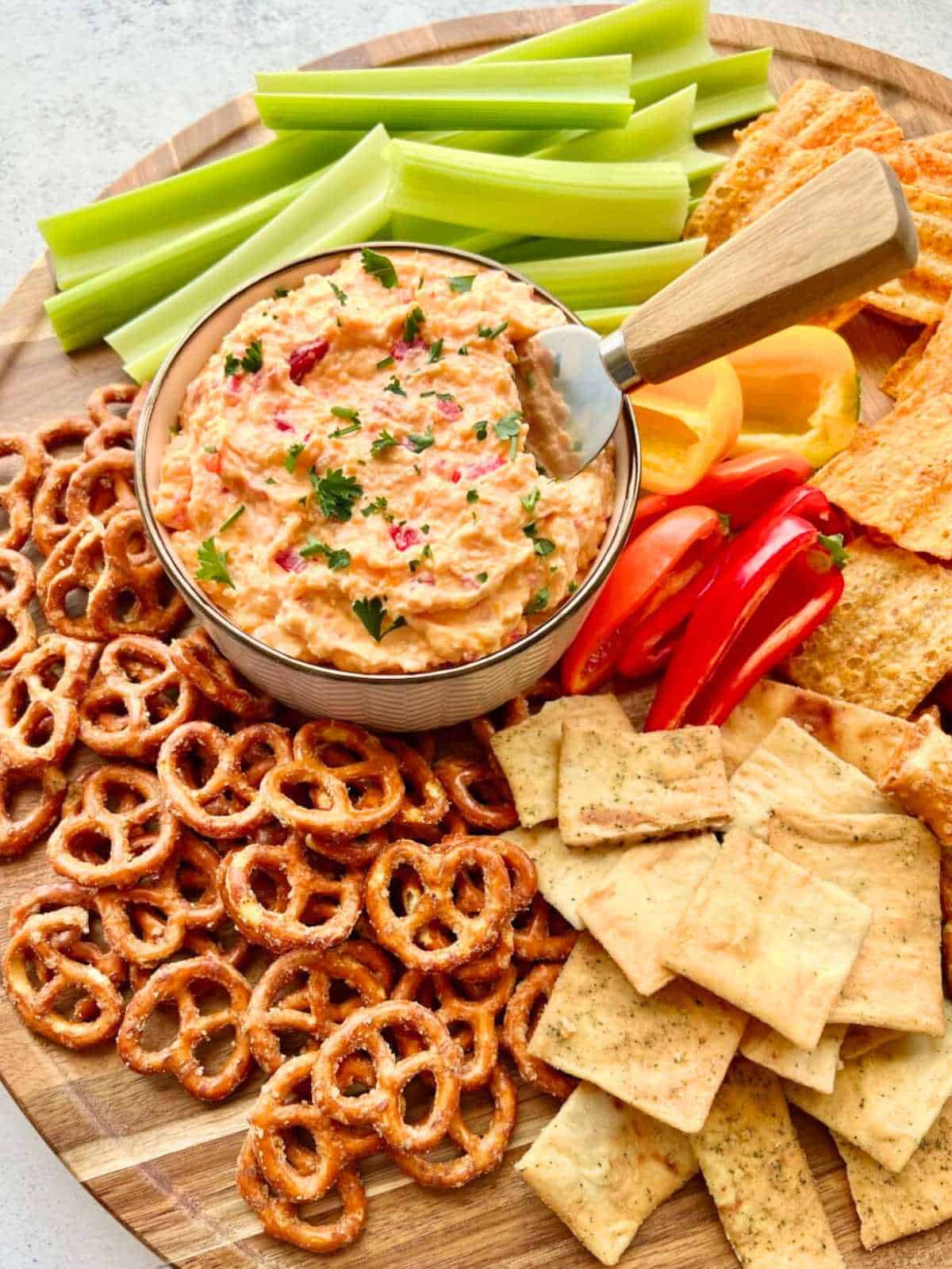 Homemade Pimento Cheese dip on a board with veggies and chips.