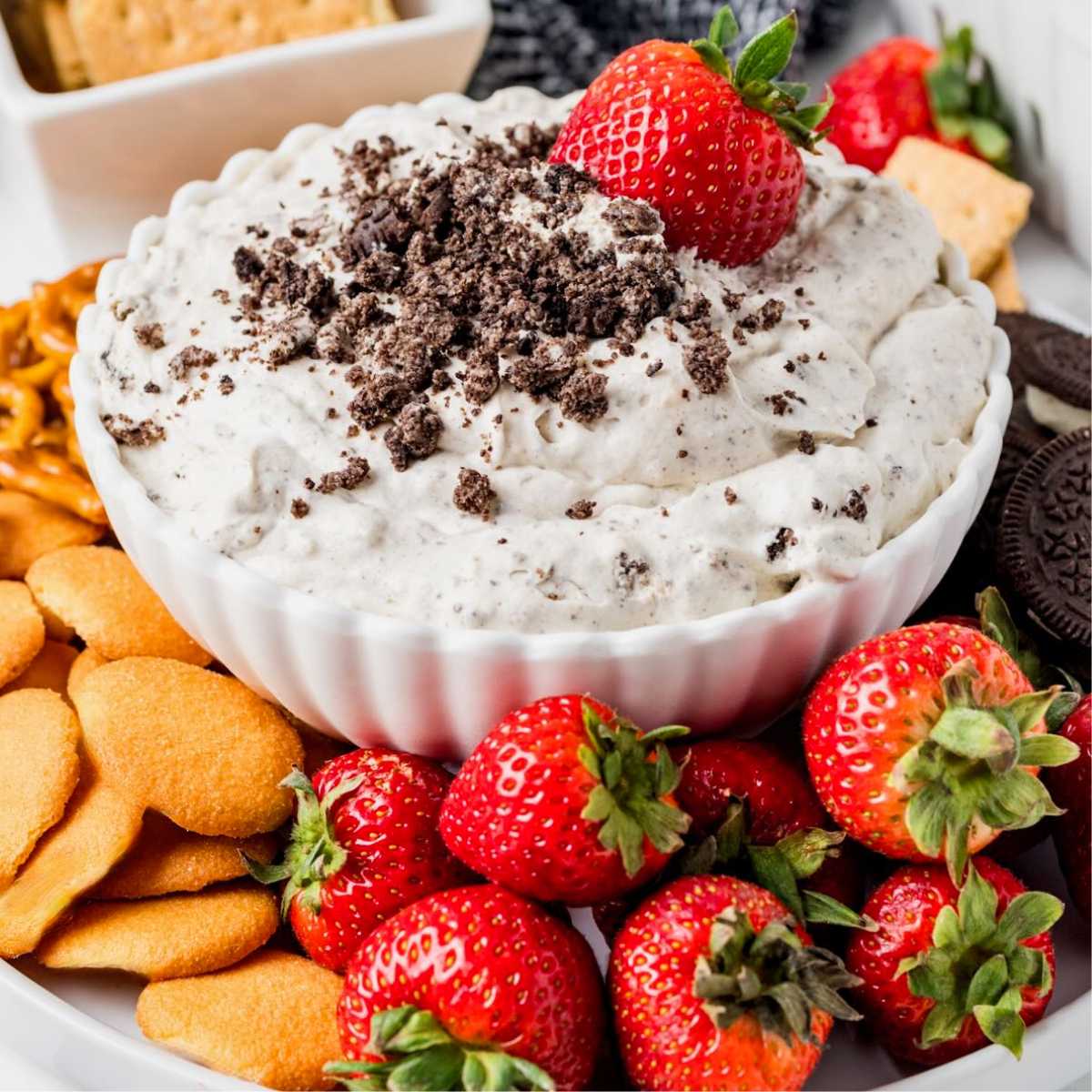 Oreo Dip surrounded by strawberries and vanilla wafers.