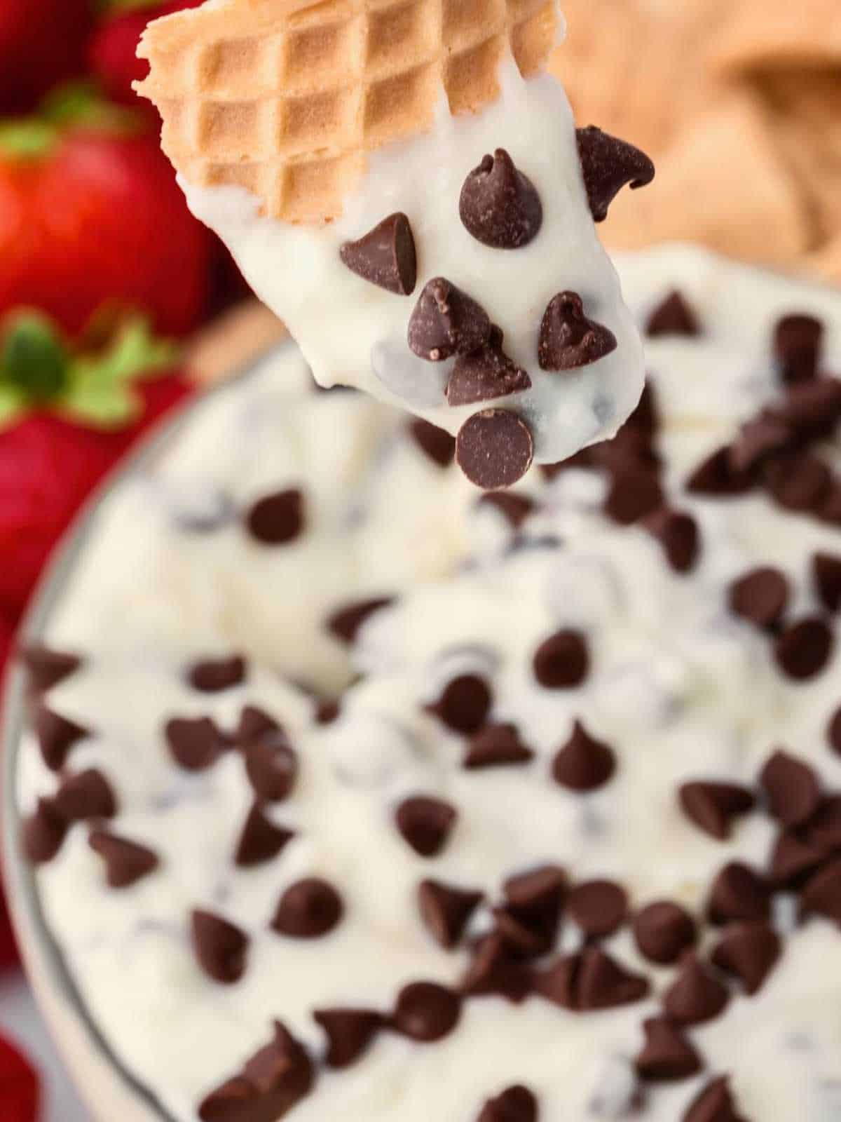 Waffle cone dipped into cannoli dip with chocolate chips.