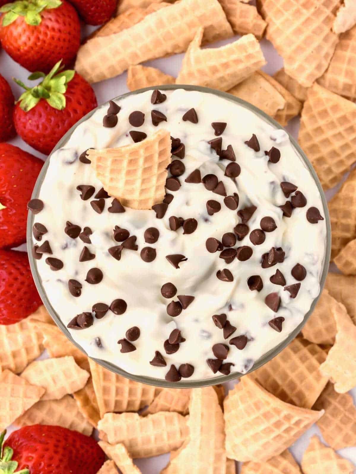 Cannoli dip surrounded by broken waffle cones.