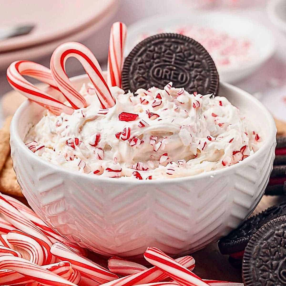 Candy Cane Peppermint Dip in a bowl with Oreo cookies and candy cane dippers.