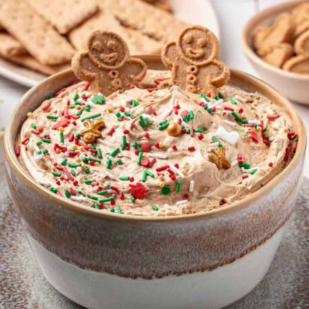 Gingerbread dip with sprinkles and gingerbread men on top.