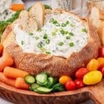 Knorr Spinach Dip recipe in a carved bread bowl surrounded by veggies.