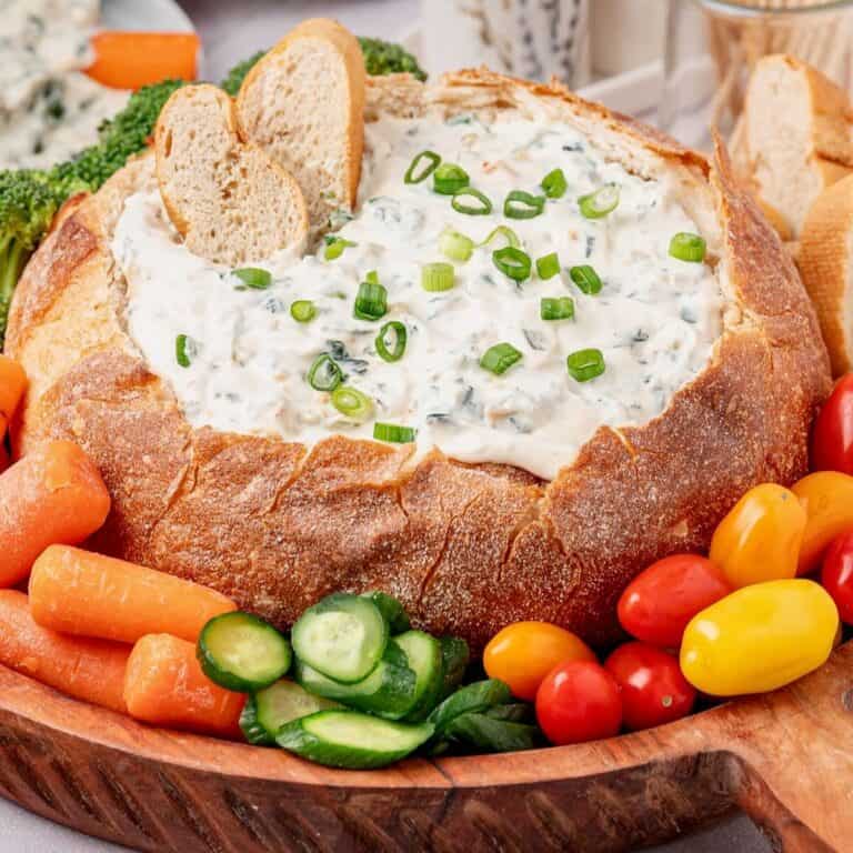Knorr Spinach Dip recipe in a carved bread bowl surrounded by veggies.