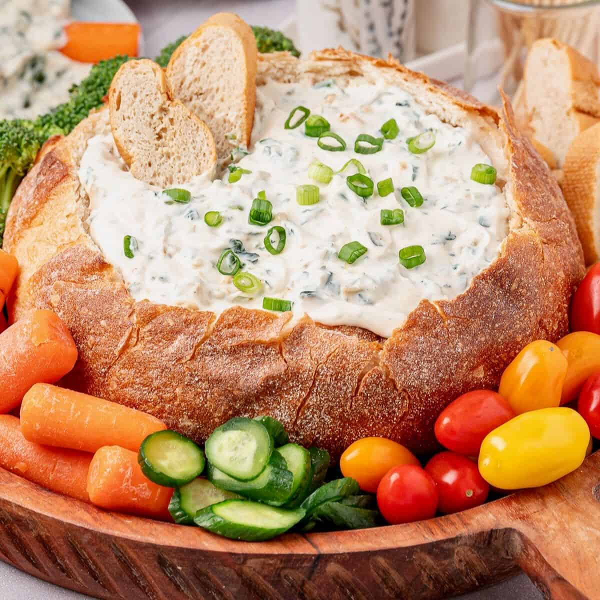 Knorr Spinach Dip recipe in a carved bread bowl surrounded by veggies.