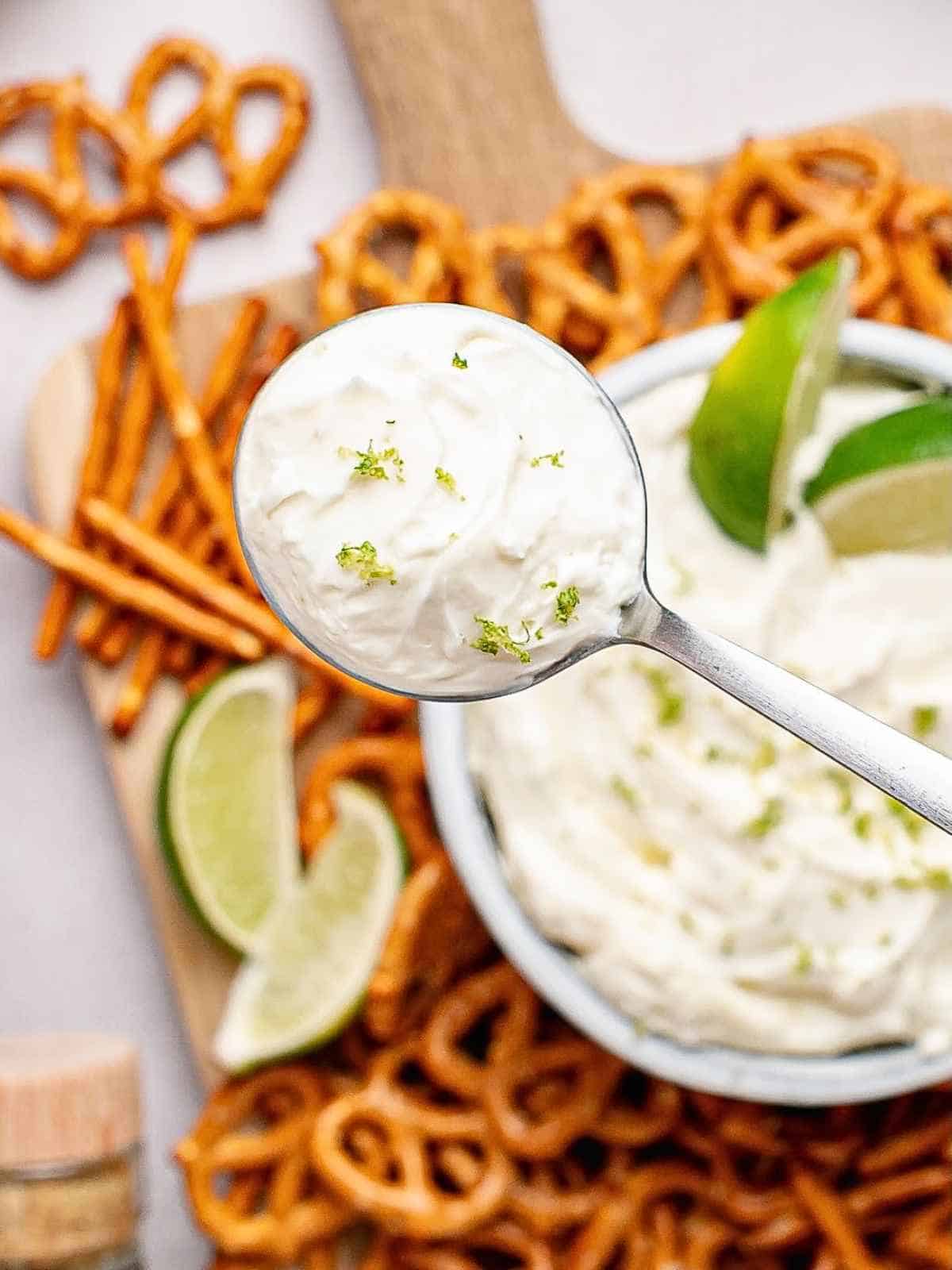 Spoonful of margarita dip held up over a bowl.