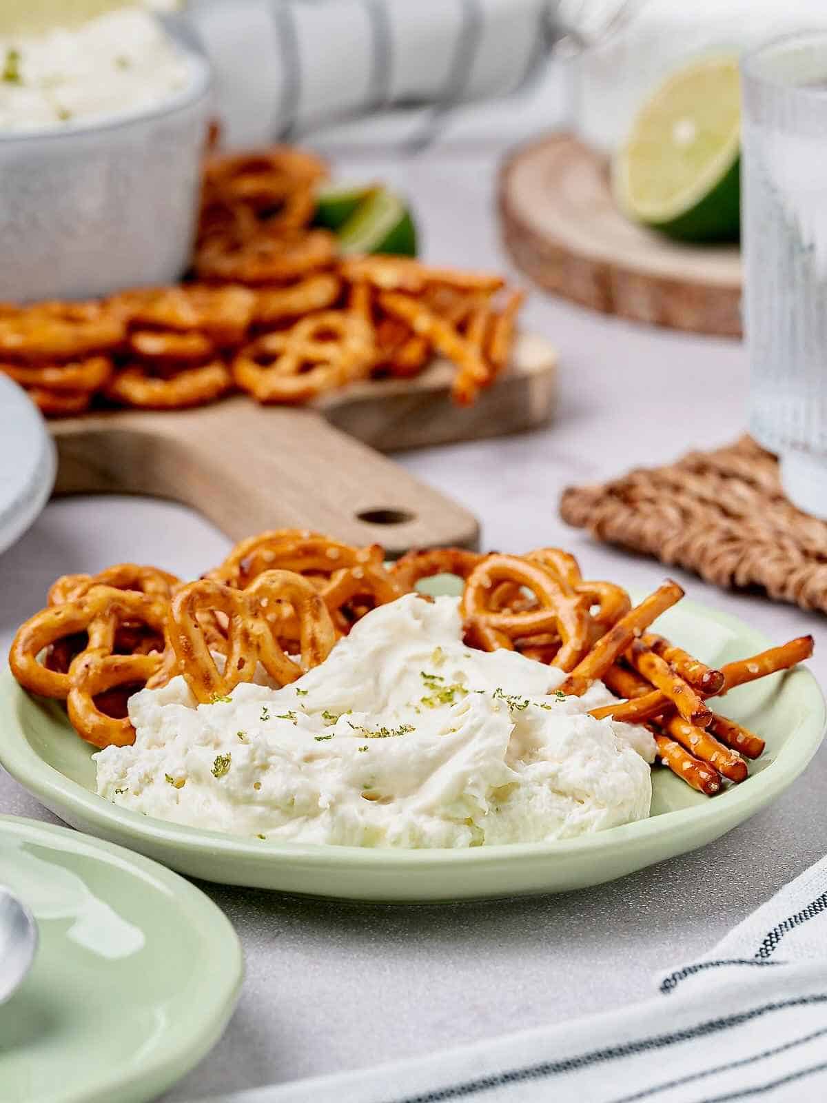A plate of margarita dip surrounded by salted pretzels.