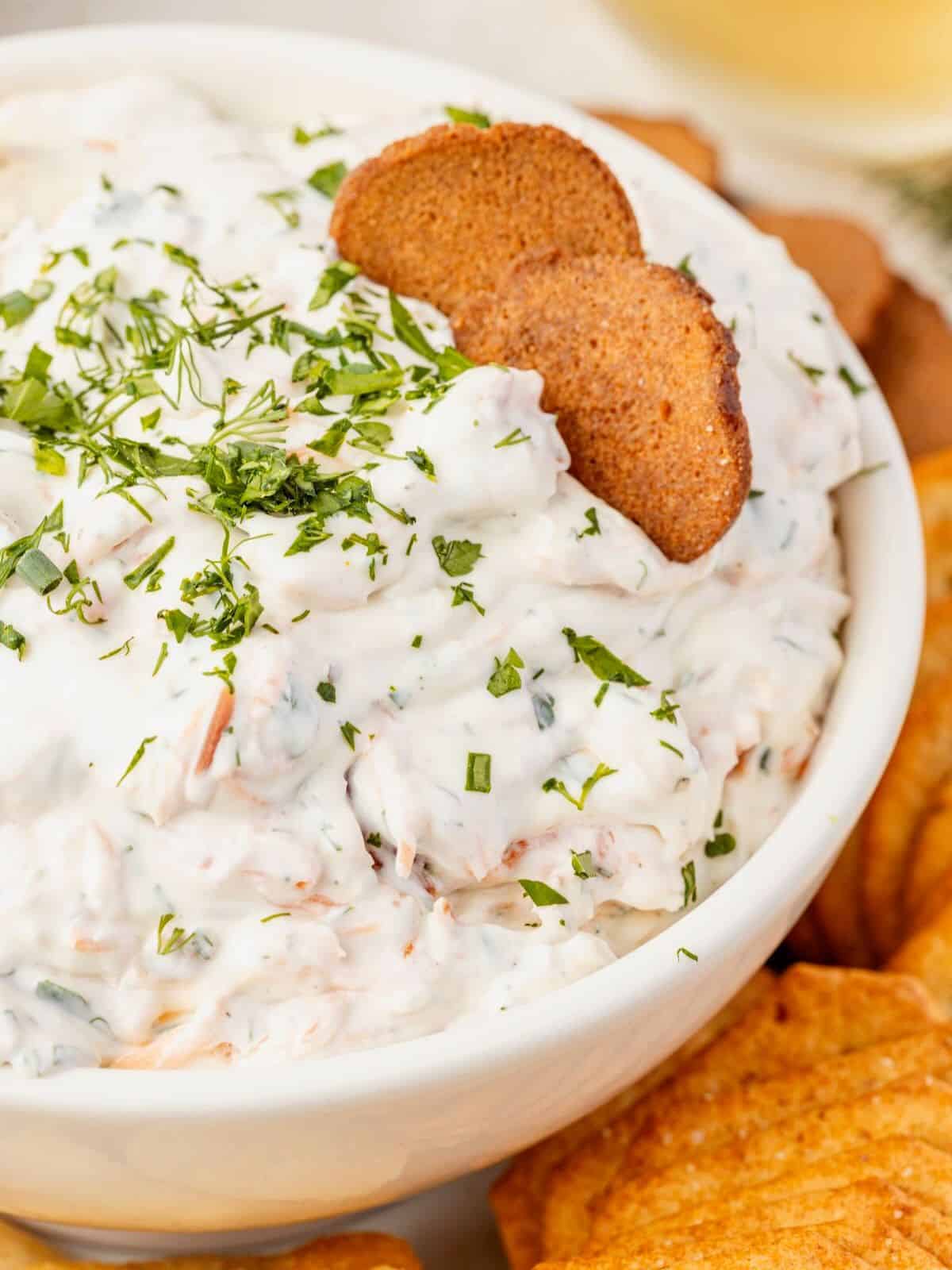 Toast dipping into smoked salmon dip.