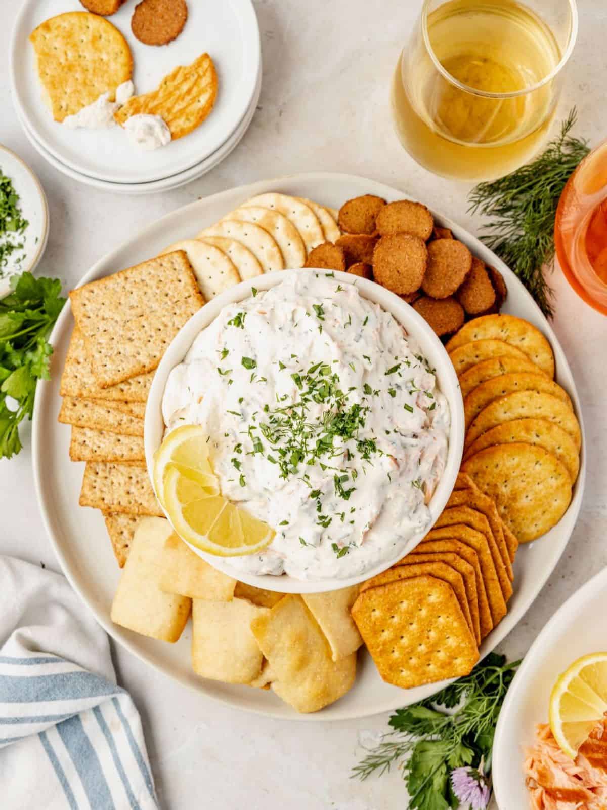 Bowl of smoked salmon dip surrounded by crackers.