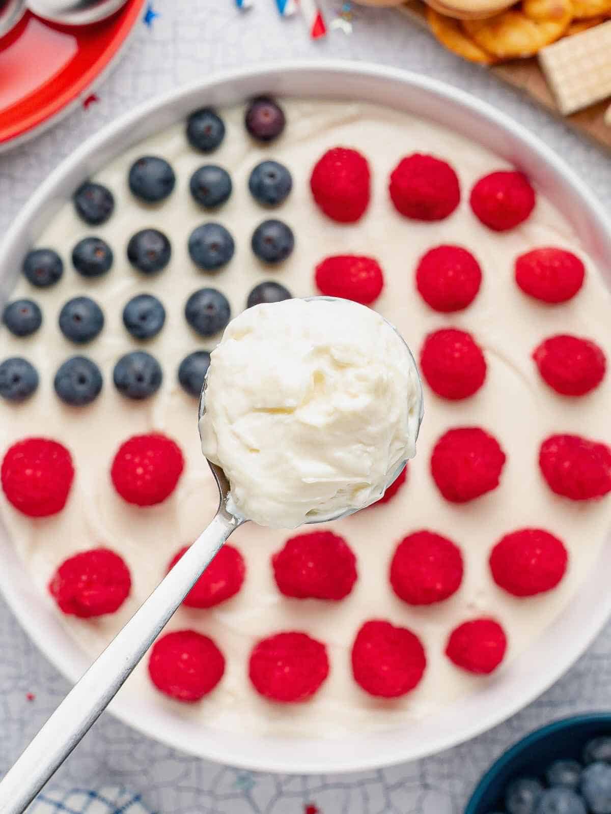 Scoop of dip over a bowl of American Flag Dip.