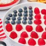 Bowl of American Flag Dessert Dip decorated with a patriotic flag made of blueberries and raspberries.