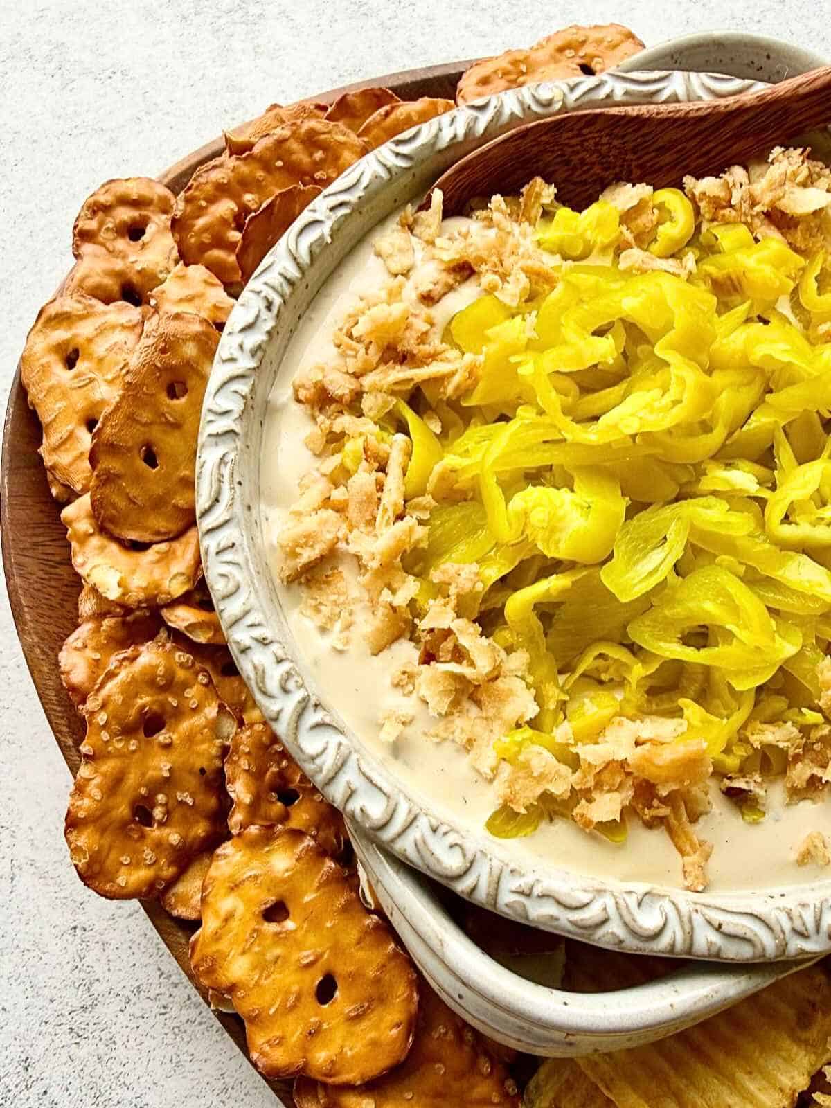 A bowl of Mississippi pot roast dip surrounded by pretzels.