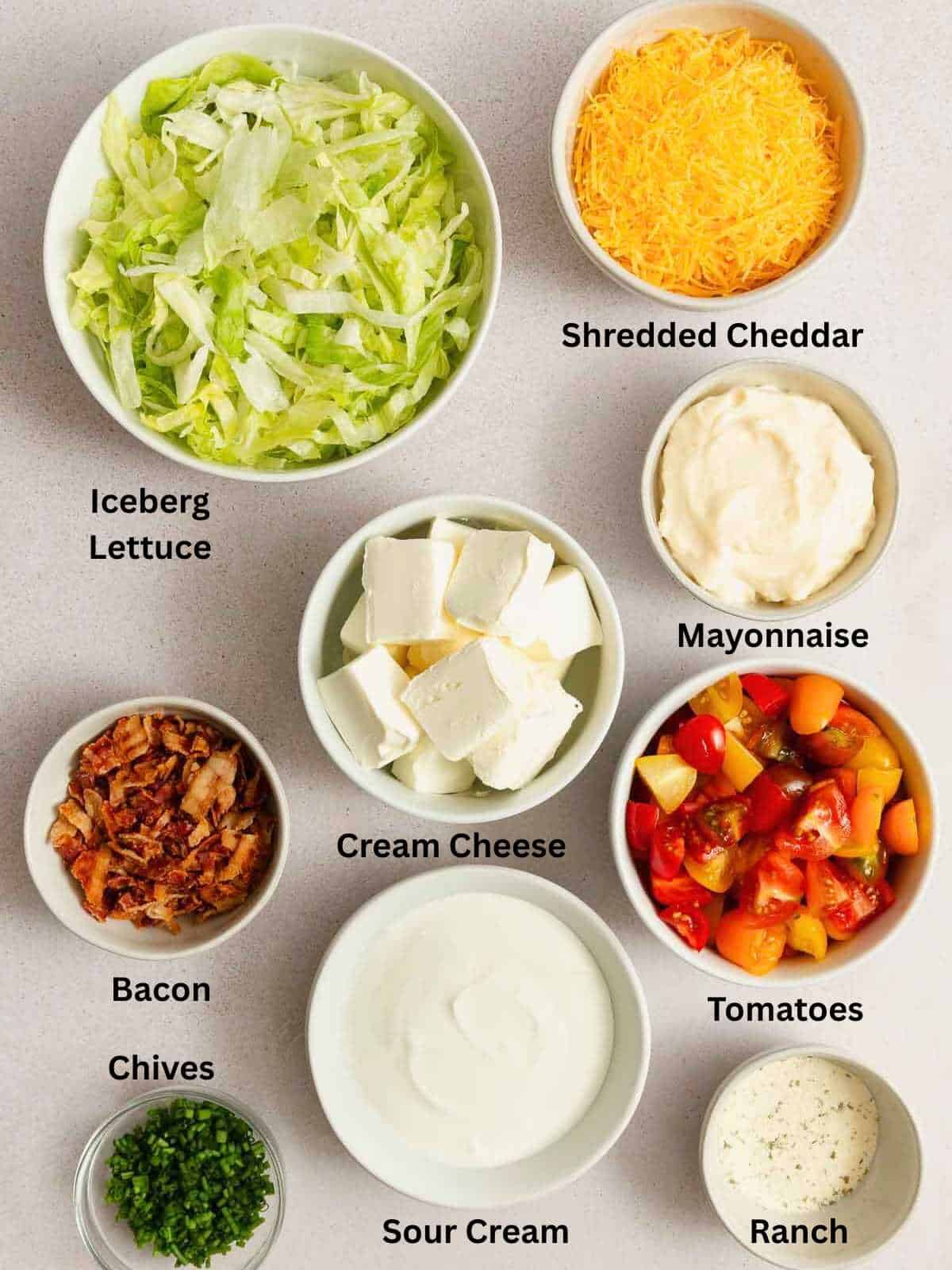 Ingredients needed to make BLT Dip in various bowls.