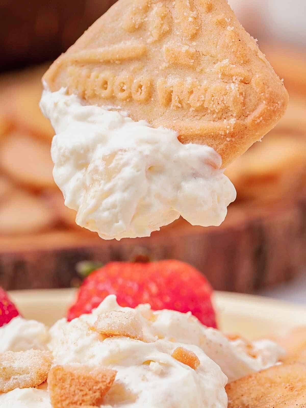 Lorna Doon cookie being dipped into banana pudding dip.