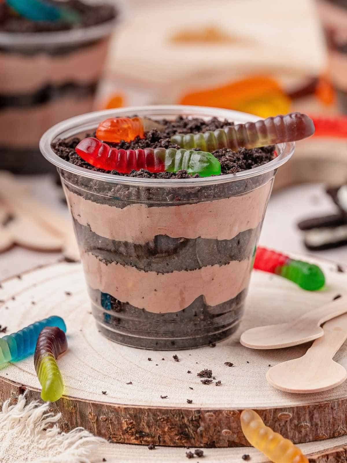Dirt cake individual cup layered with Oreo cookies and gummy worms.