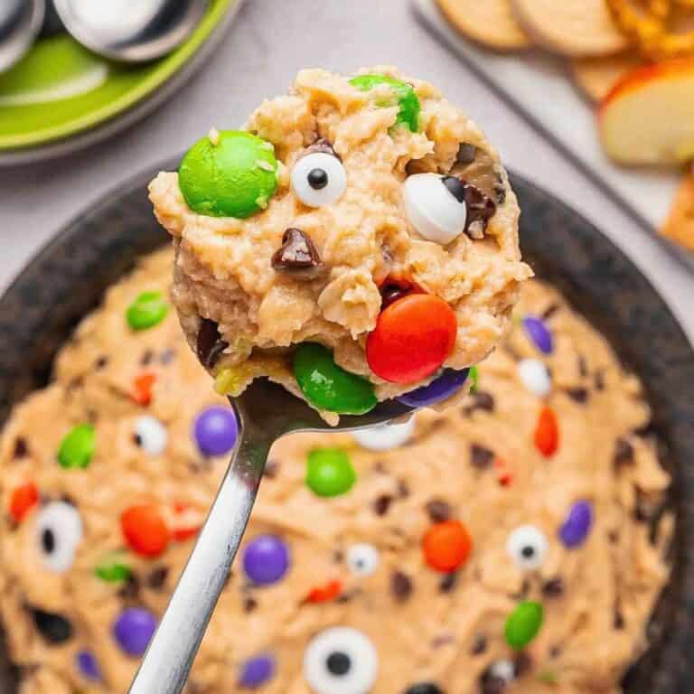 Scoop of Edible Monster Cookie Dough being raised above a bowl.